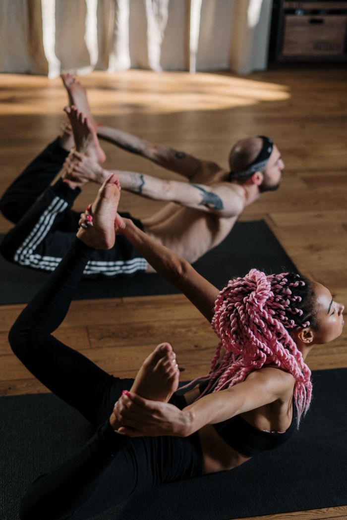 services-01 Yoga class with diverse individuals practicing together indoors, promoting wellness and fitness.